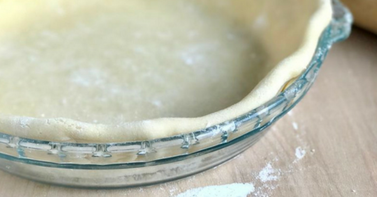 Dairy free pie crust in a glass pie dish, before it goes in the oven.