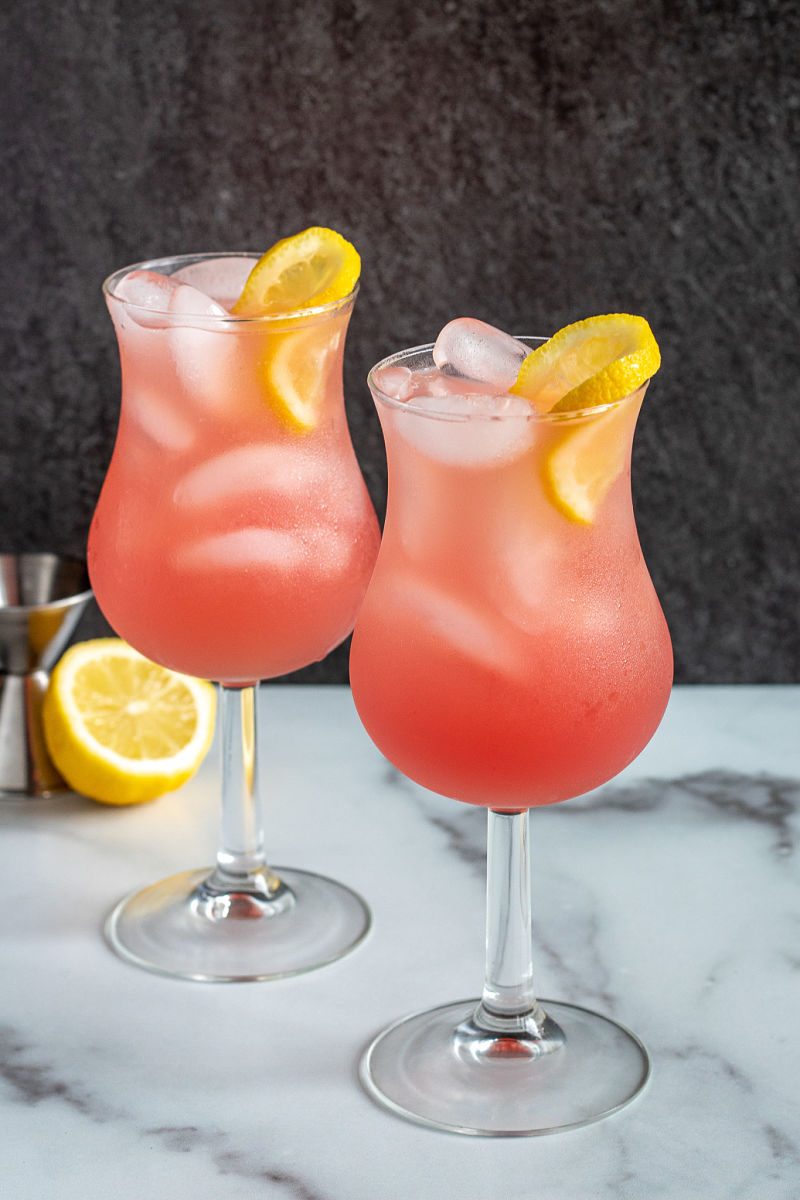 Cranberry grapefruit fizz cocktail in two glasses with lemon