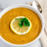red lentil soup with lemon in white bowl