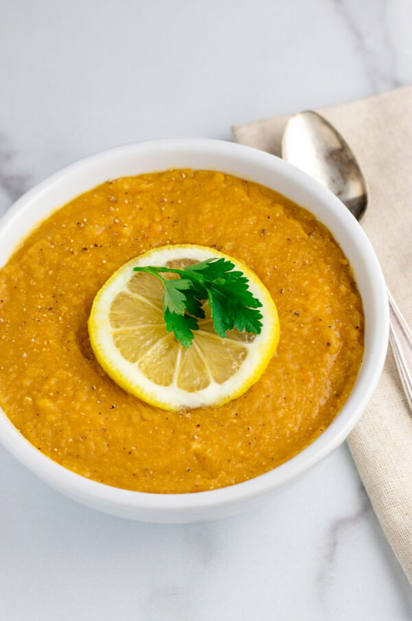 red lentil soup with lemon in white bowl